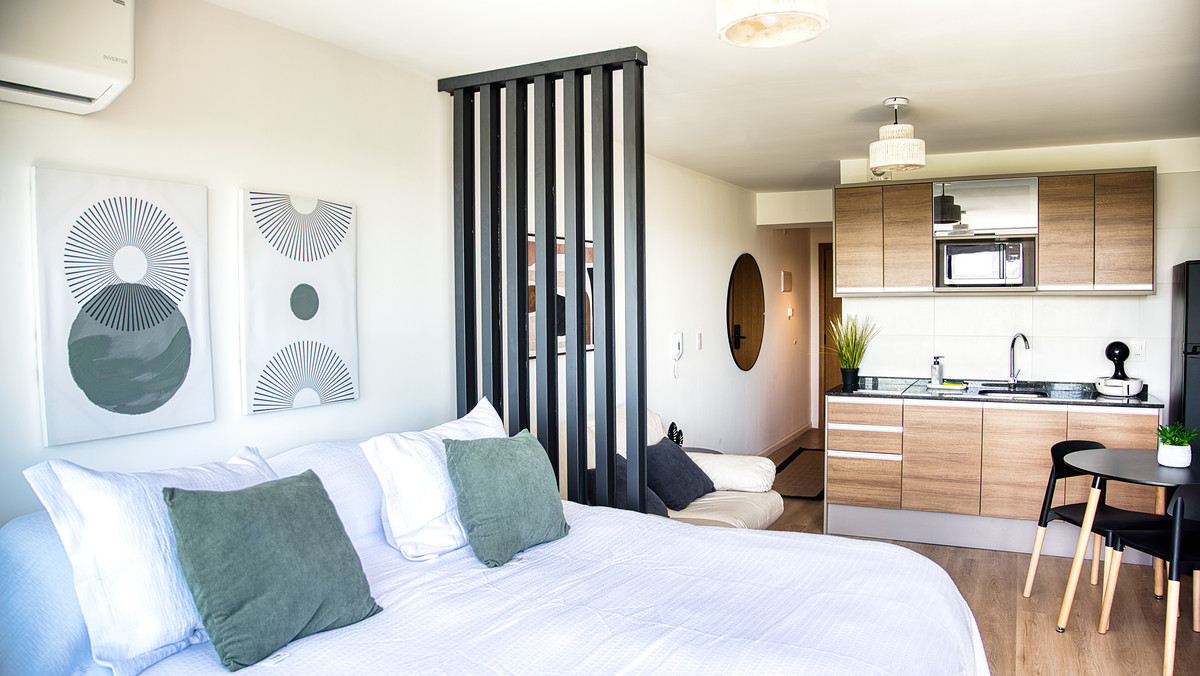 Monoambiente en Pocitos: cama, separador, cocina integrada y mesa en un solo ambiente